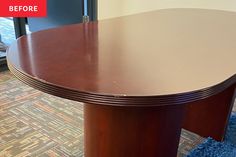 an oval conference table with curved edges on carpeted floor