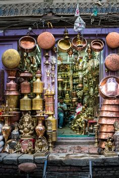 a store front with lots of copper pots and pans