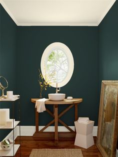 a bathroom with pink walls and white trim on the walls, along with a round window