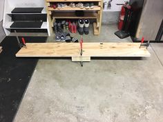 a wooden bench sitting in the middle of a room filled with shoes and workbench