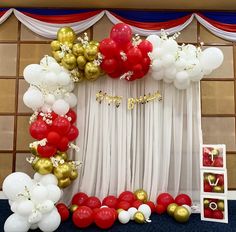 the balloon arch is decorated with red, white and gold balloons