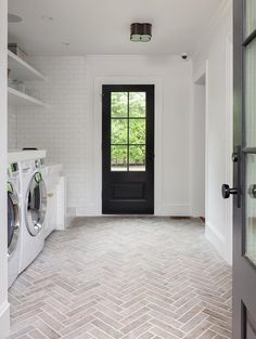 a washer and dryer in a room with brick flooring on the walls