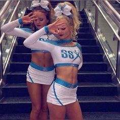 two cheerleaders are standing on the stairs