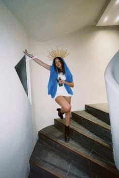 a woman is standing on the stairs with her arms outstretched