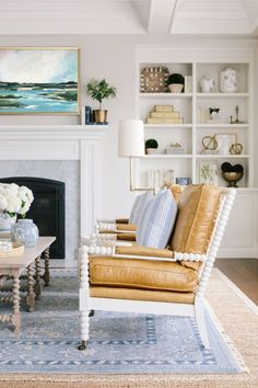 a living room filled with furniture and a fire place in front of a white fireplace