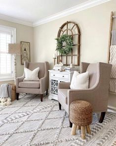 a living room with two chairs and a rug on the floor in front of a window