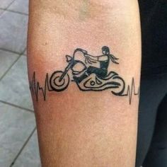 a tattoo on the arm of a person with a motor bike and heartbeats behind it