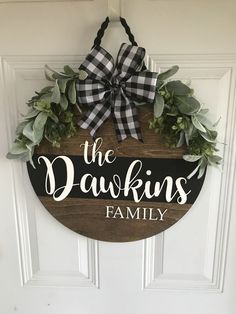 the dawkins family door hanger is made from wood and has a black and white checkered bow on it