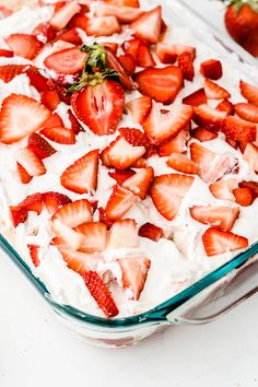 a glass dish filled with strawberries on top of a table