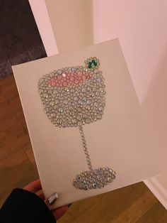 a hand holding up a card with an image of a wine goblet on it