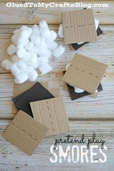 several pieces of cardboard sitting next to cotton balls on a wooden table with text overlay