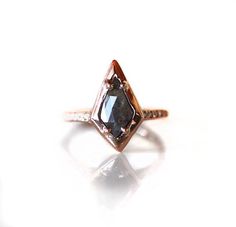 a diamond ring with a brown and white stone in the center on a white surface