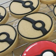 decorated cookies with black and white frosting are on a cooling rack next to each other