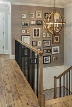 a staircase with pictures on the wall and a chandelier