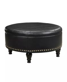 a black ottoman with studded trimmings on the legs and footrests