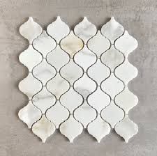 a white tile with an intricate design on the back wall, and a gray background