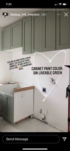 a kitchen with green cabinets and white walls has a heart drawn on the wall above it