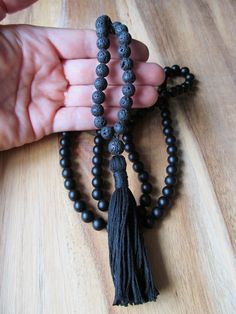 "108 Bead Matte Black Onyx and Black Lava Bead Mala This traditional 108 bead mala features a stunning combination of matte black onyx beads and black lava beads. It is finished off with a hand tied matching black tassel. Excellent for meditation or to wear as a beautiful long necklace. Materials: 8mm Matte Black Onyx Beads 8mm Black Lava Beads Black Knotting Cord Cotton Tassel Size info: 108 bead mala plus guru bead measures approximately 35 inches in circumference with a 3\" tassel. * All jewe Black Bohemian Mala With Gemstone Beads, Black Bohemian Beads For Meditation, Bohemian Black Beads For Meditation, Black Bohemian Mala With Round Beads, Bohemian Black Mala With Round Beads, Bohemian Black Beaded Mala, Black Tassel Necklaces As Gift, Black Tassel Necklace As Gift, Black Tassel Necklace Gift