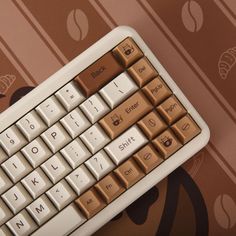 a computer keyboard sitting on top of a brown and white wallpapered flooring