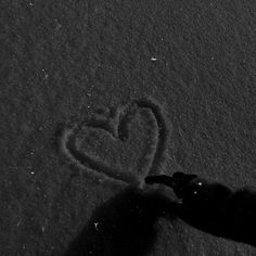 someone is drawing a heart in the snow