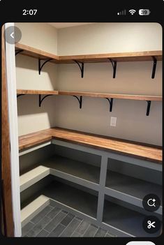 an empty walk in closet with wooden shelves