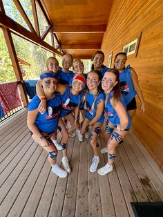 a group of young women standing next to each other on top of a wooden floor