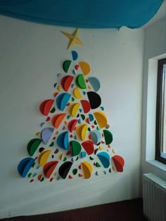 a colorful christmas tree hanging on the wall