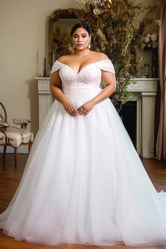 a woman in a white wedding dress posing for the camera with her hands on her hips