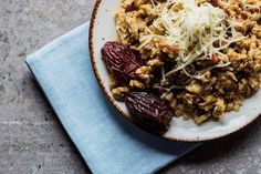 a white plate topped with granola and raisins on top of a blue napkin