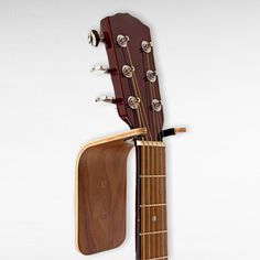 an acoustic guitar hanging from the back of it's neck with its frets