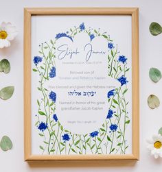 a blue and white floral design on a framed paper with flowers around the edges in front of it