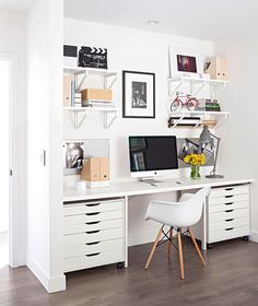 a white desk with two computers on top of it and some shelves above the desk