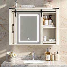 a bathroom vanity with a lighted mirror above it and shelves on the wall next to it