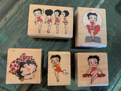 four rubber stamps with cartoon characters on them sitting on a glass table top next to each other