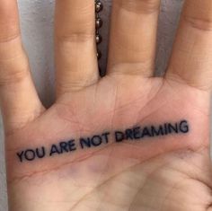 a person's hand with the words you are not dreaming written on it,