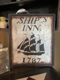 an old ship's inn sign is displayed on a shelf next to other items