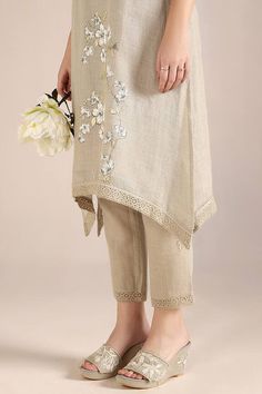 Natural kurta with camelia flower print and crochet lace embroidered cutwork border. Paired with pant. - Aza Fashions Beige Floral Print Pants For Spring, Spring Floral Print Beige Pants, Spring Beige Floral Print Pants, Beige Floral Embroidered Bottoms For Spring, Spring Beige Floral Embroidered Bottoms, Beige Floral Embroidered Pants, Beige Floral Embroidery Pants For Summer, Traditional Floral Print Bottoms For Spring, Traditional Spring Floral Print Bottoms