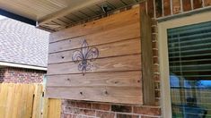 a wooden sign with a fleur de lis painted on it's side