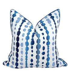 a blue and white striped pillow on a white background with black dots in the middle