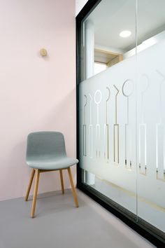 a chair sitting in front of a glass wall with scissors on it's side