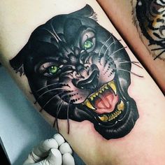 two black and grey tattoos with green eyes