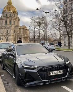 two cars are parked on the side of the road in front of a building with a dome