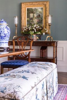 a blue and white vase sitting on top of a wooden table next to a bench