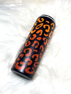 an orange and black leopard print canister sitting on a white fur covered surface with the words $ 350 printed on it