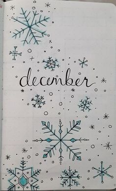 a notebook with snowflakes and the word december written in black ink on it