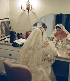 the bride is getting ready to go into her wedding dress and make up in front of the mirror