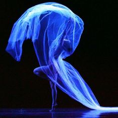 a woman in blue is performing on stage