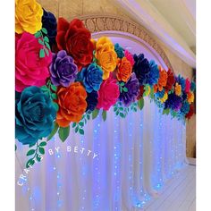 colorful paper flowers are lined up on the wall