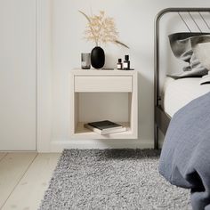 a bedroom with a bed, night stand and bedside table in the corner next to it