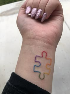 a person's wrist with a puzzle tattoo on it